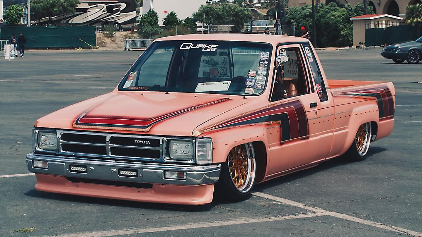 Pink Toyota pickup with copper-toned Klutch K3020 wheels, viewed from the front three-quarter angle