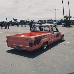 Rear three-quarter view of a pink Toyota pickup showing its side graphics and Klutch K3020 rear wheel