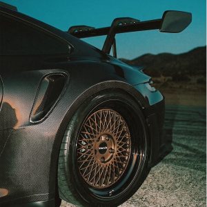 Angled close-up of a bronze-toned Klutch mesh rear wheel with a dark reflective lip on a Porsche 911