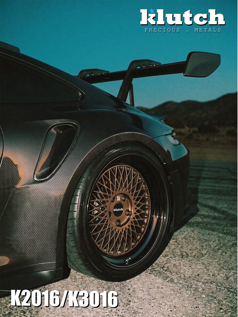 Angled close-up of a bronze-toned Klutch mesh rear wheel with a dark reflective lip on a Porsche 911