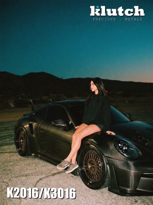 A woman seated on the front fender of a carbon-fiber Porsche 911 fitted with bronze-toned Klutch mesh wheels